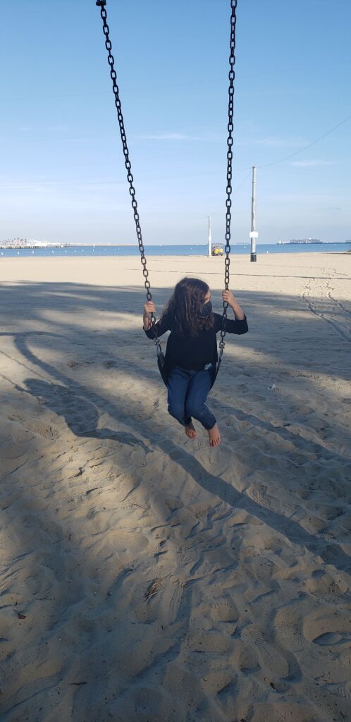 child swinging at the beach